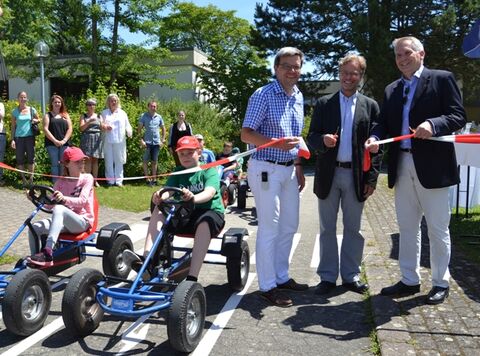 Start frei für den wieder eröffneten Verkehrsübungsplatzes des Hegau-Jugendwerks. Sie machten den Weg für die bereits in Kettcars wartenden Patienten frei (v.l.n.r.) Dr. Axel Galler, ärztlicher Leiter des Kinderhauses, Dr. Klaus Scheidtmann, ärztlicher Direktor, und Graf Philipp von Magnis, stellvertretender Vorsitzender des Jugendwerk-Fördervereins. Bild: aj